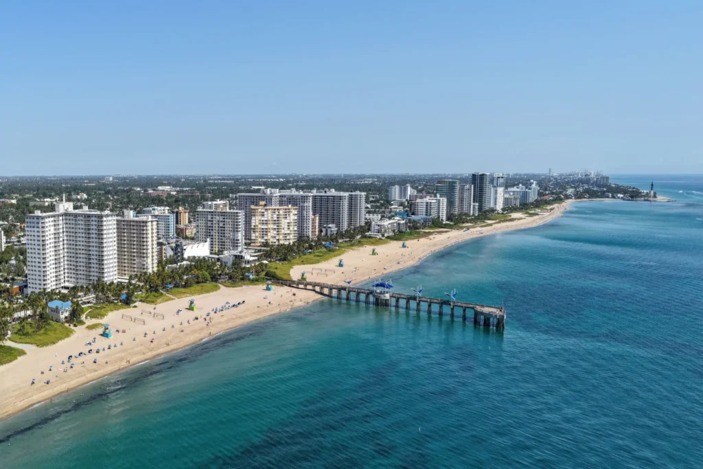 Vista aérea de Pompano Beach, Florida, con la playa, el muelle Fisher Family Pier y el faro de Hillsboro Inlet al fondo